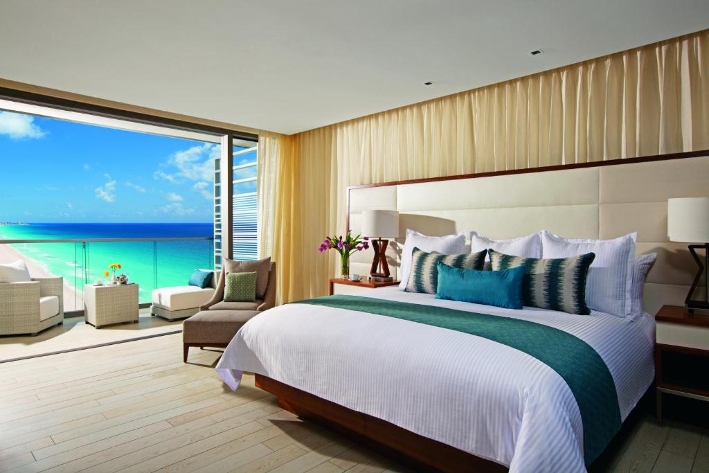 Suite premium con cama king, balcón y vista al océano en hotel de lujo en Cancún